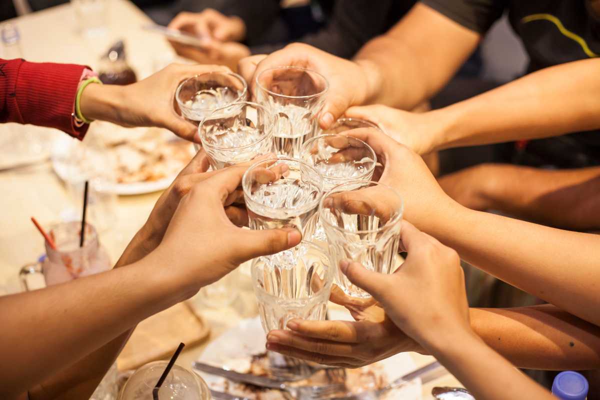 Tavola imbandita con piatti tipici capresi (insalata caprese, ravioli capresi, pesce fresco) su una terrazza panoramica, con i Faraglioni sullo sfondo e atmosfera mediterranea